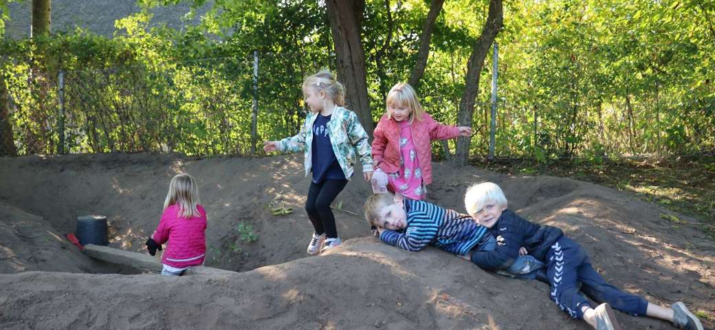 Børn i leg i bakket terræn