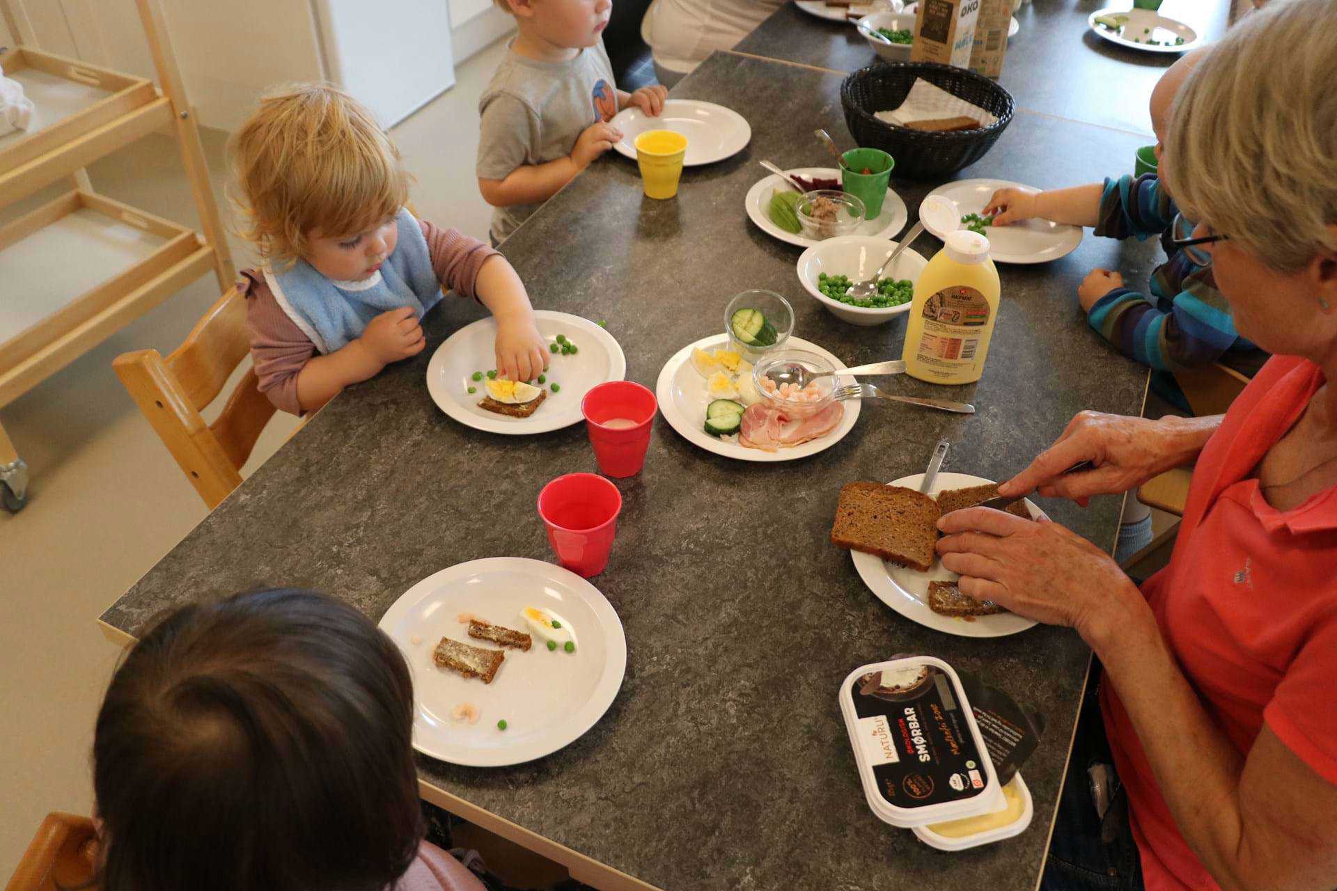 Dagplejebørn og dagplejer spiser frokost