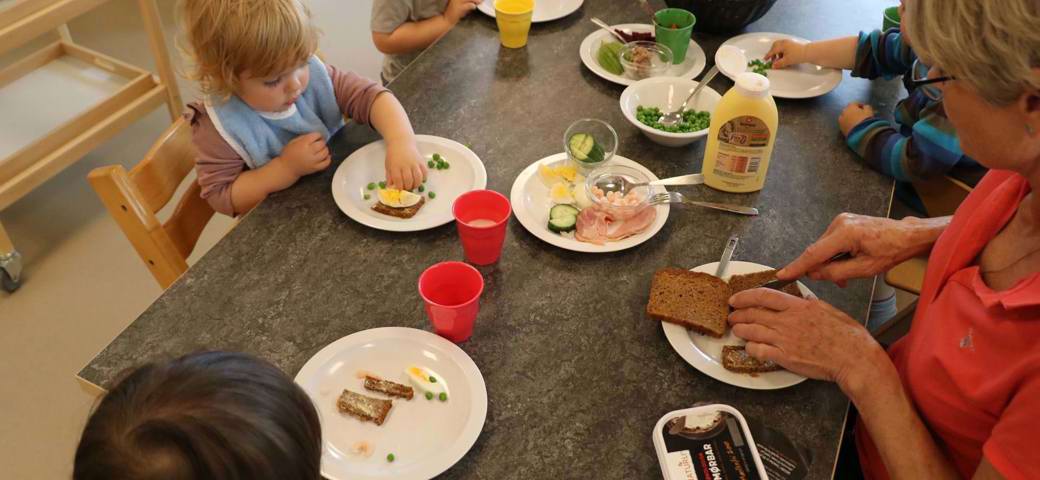 Dagplejebørn og dagplejer spiser frokost