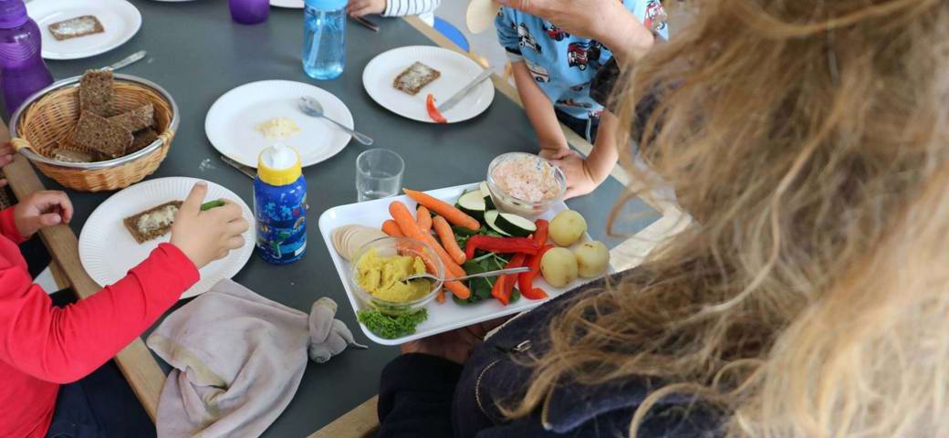 Pædagog viser pålæg frem ved frokostmåltid