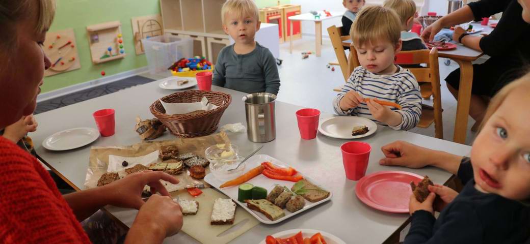 Børn spiser frokost omkring bord