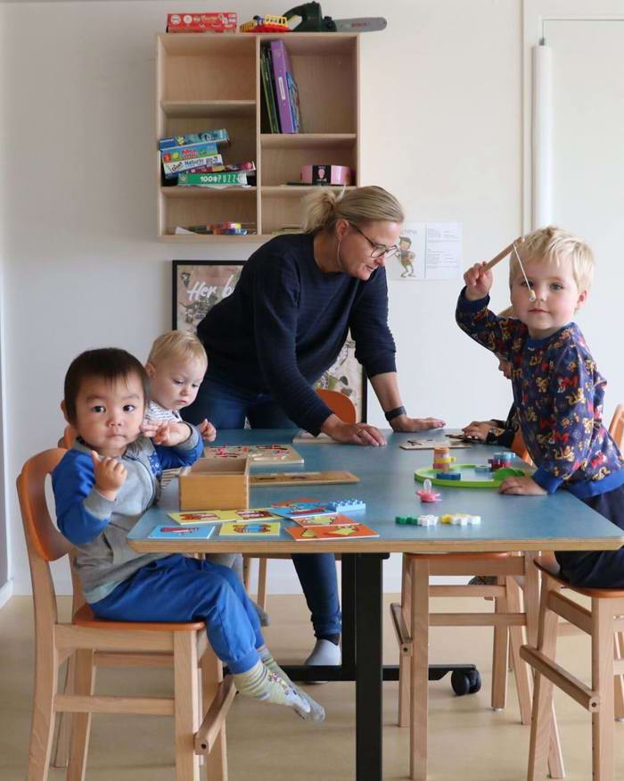 Vuggestuebørn laver puslespil omkring bord