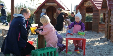 Vuggestuebørn og pædagoger i sandkasse