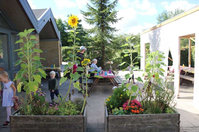 Blomsterkummer og børn i baggrunden