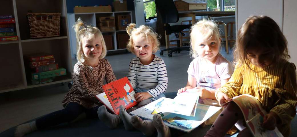 Fire piger sidder og læser bøger