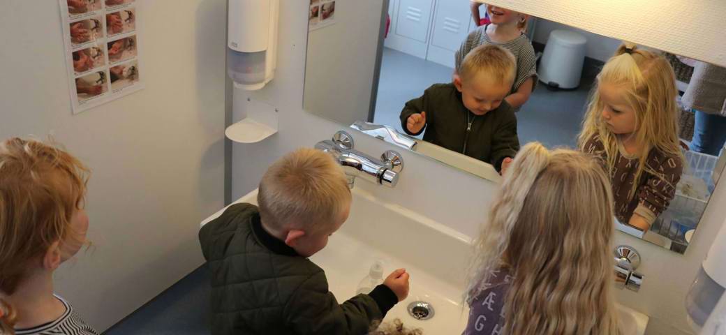 Tre børn om vasker hænder