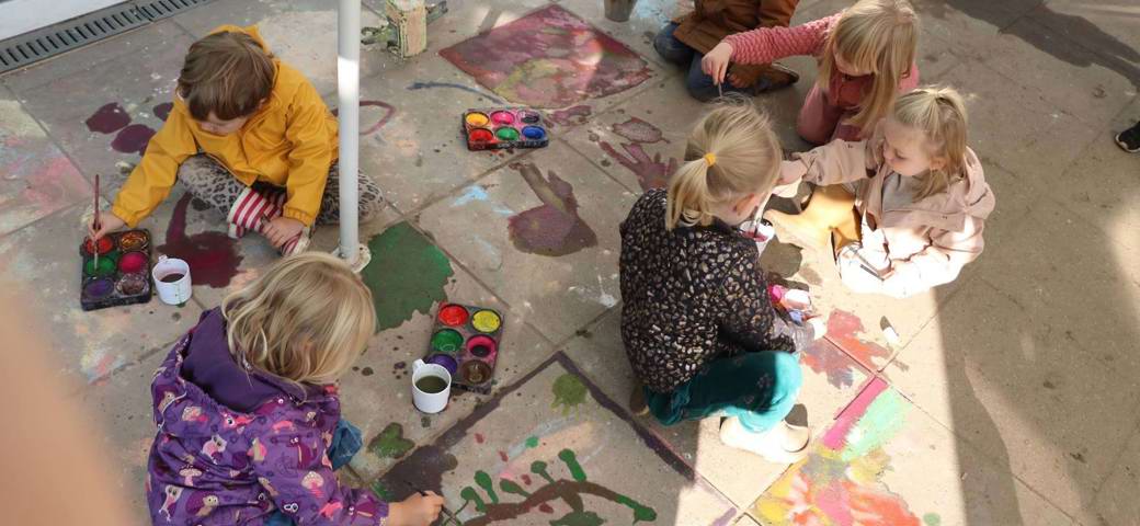 Børn maler på fliser med vandfarve
