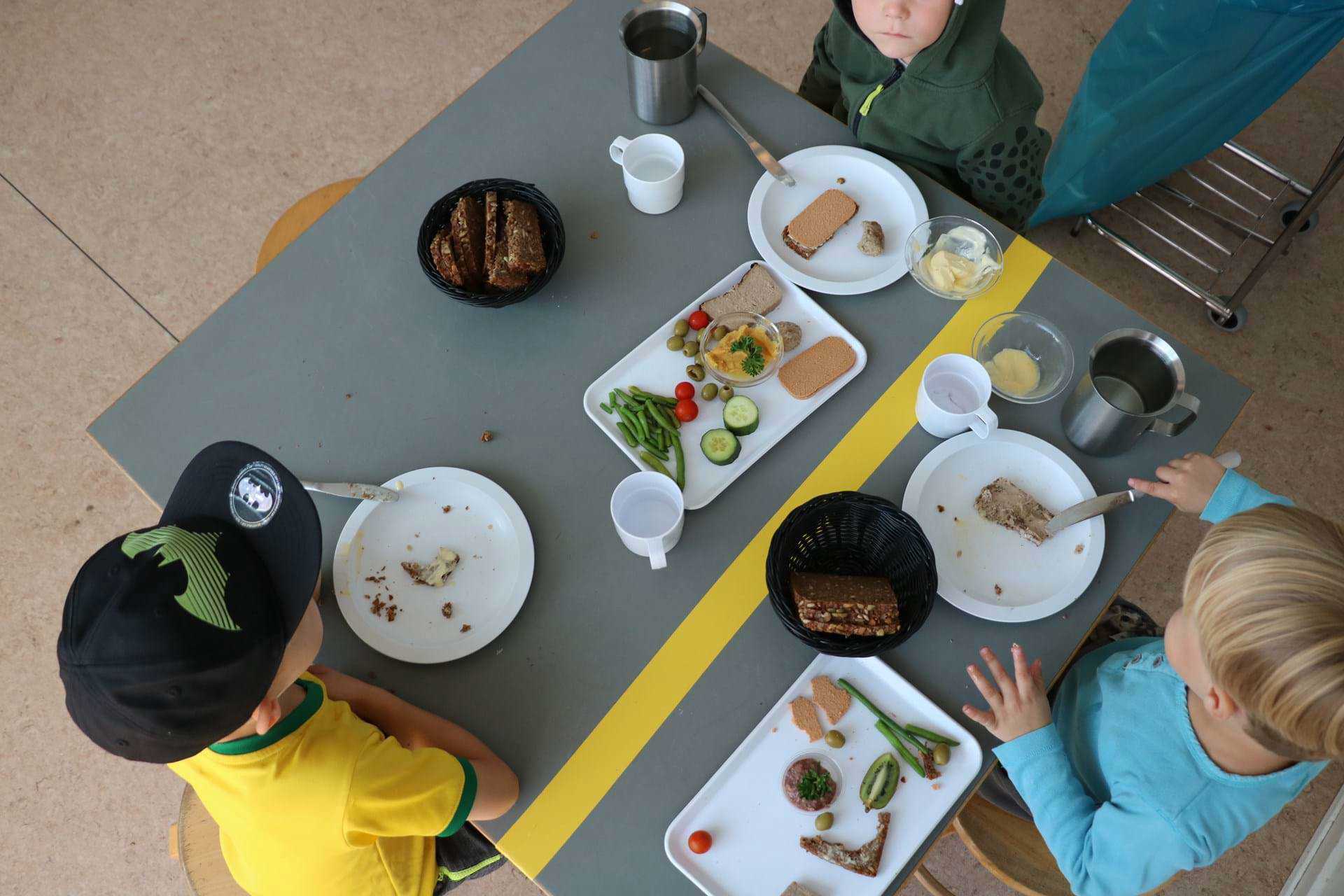 Børn spiser frokost omkring bord