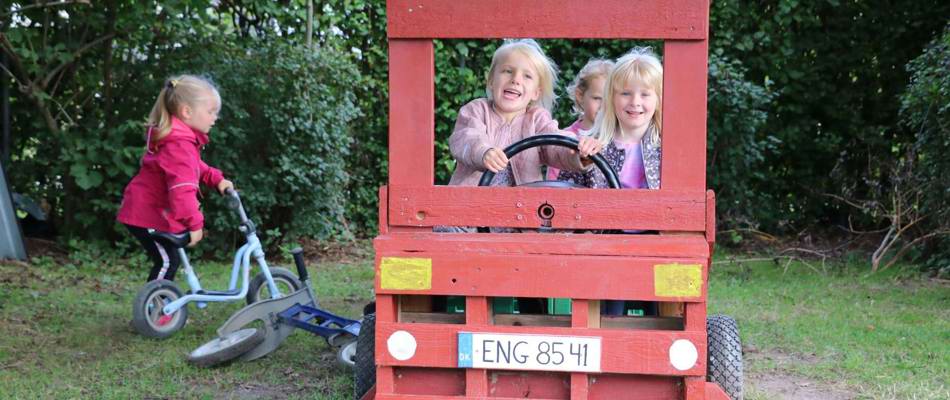 Børn i legebil udenfor