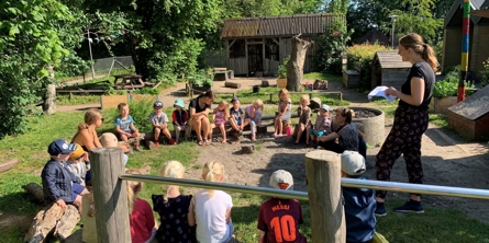 Børn og pædagoger holder samling på legeplads