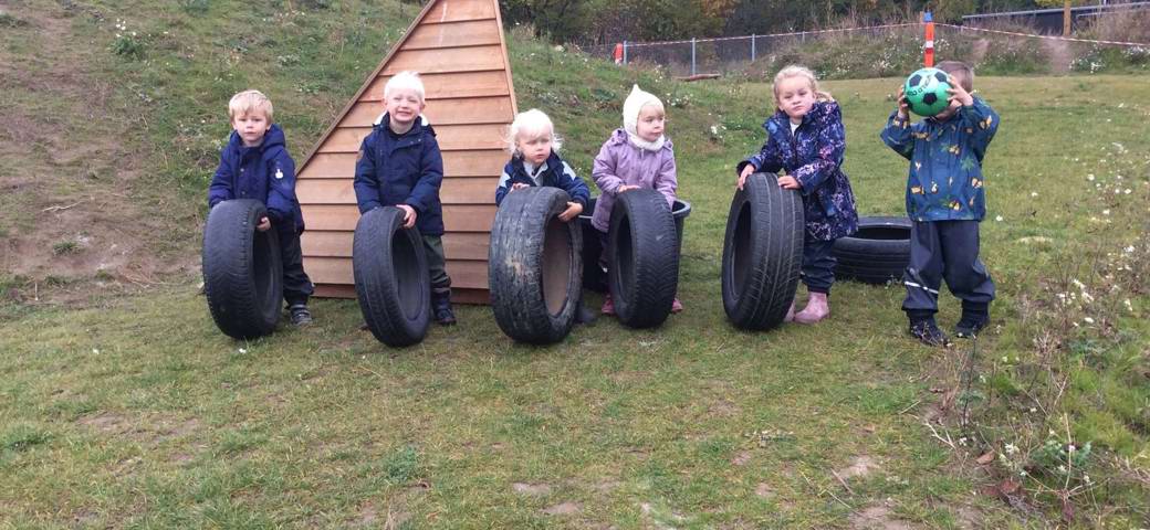 Seks børn med bildæk på række 