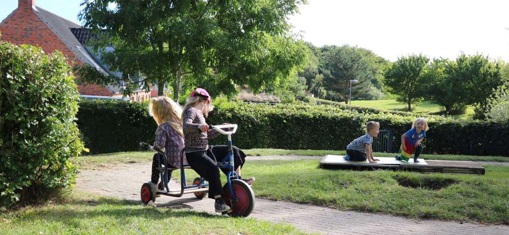 Fire børn leger ved cykelbane