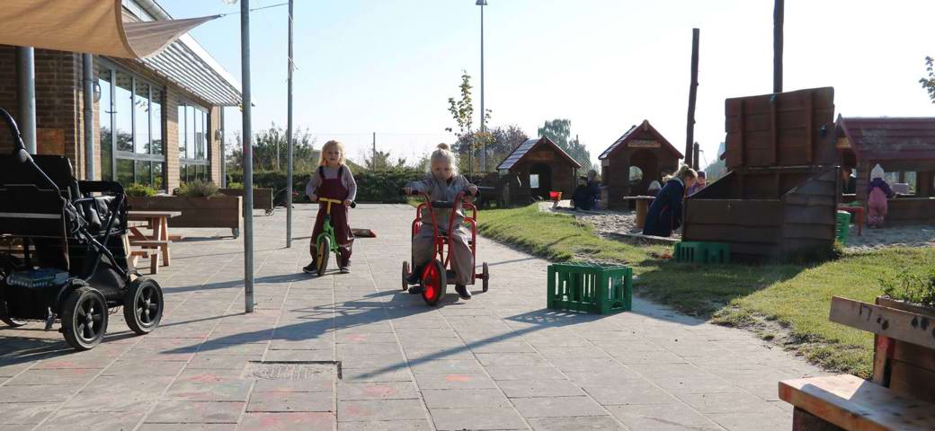 Børn på cykler på legeplads
