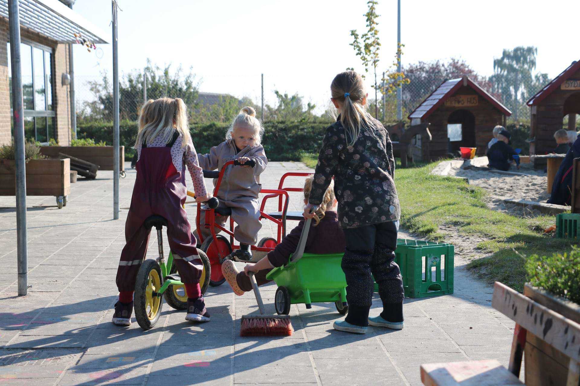 Børn på cykler på legeplads