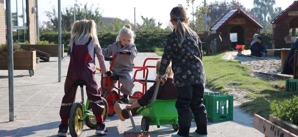 Børn på cykler på legeplads