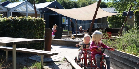 Børn på cykler på legeplads