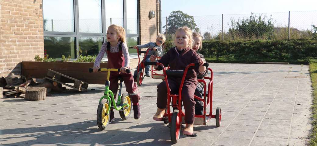 Børn cykler på legeplads